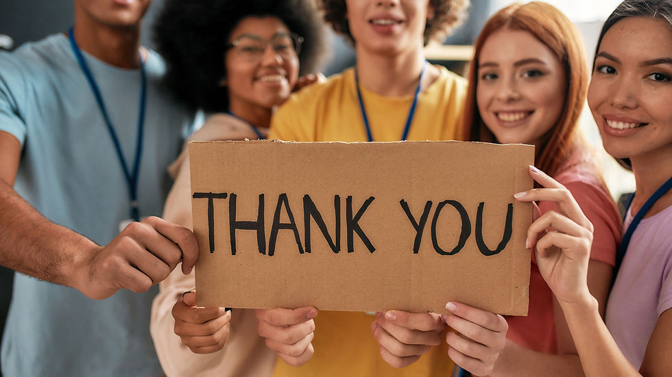 diverse group of people holding a thank you sign